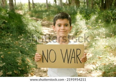 child displays "no war" sign in the wild