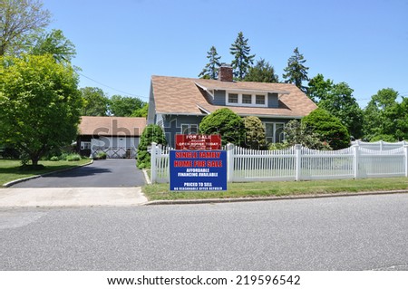 Real Estate For Sale Open House Welcome sign front yard of suburban cape style home residential neighborhood clear blue sky USA