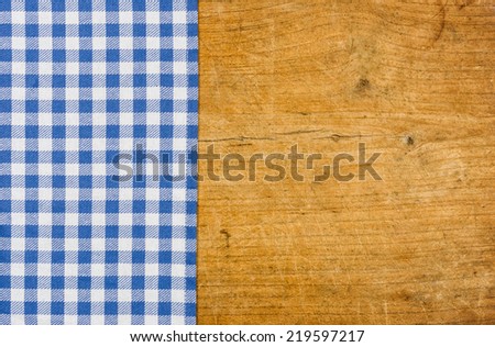Rustic wooden background with a blue checkered tablecloth