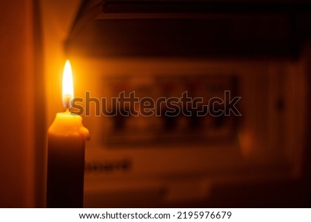 candle and electrical switches, electricity cut-off Royalty-Free Stock Photo #2195976679