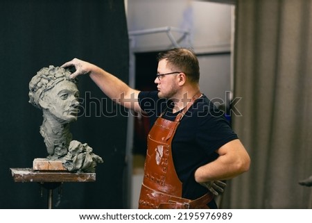 Man sculptor creates sculpt bust clay human woman sculpture. Statue craft creation workshop. Small business. Royalty-Free Stock Photo #2195976989