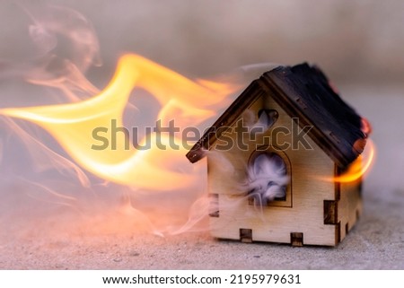 toy wooden house is on fire. fire, disaster. High quality photo Royalty-Free Stock Photo #2195979631