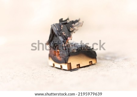 charred toy wooden house after a fire. disaster concept. High quality photo