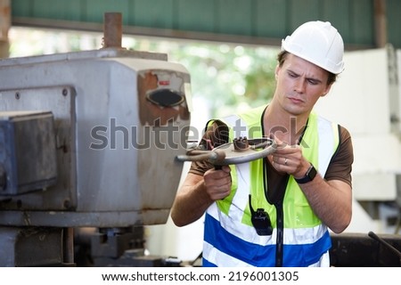 engineer or factory worker checking old lathe machine in factory