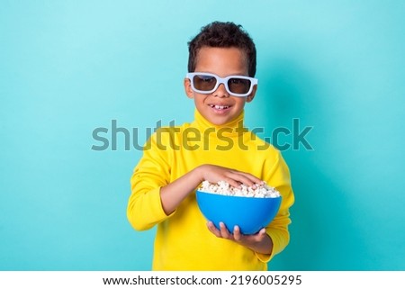 Photo of cute boy dressed stylish clothes 3d eyewear hand arm hold plate snack enjoy film empty space isolated on cyan color background