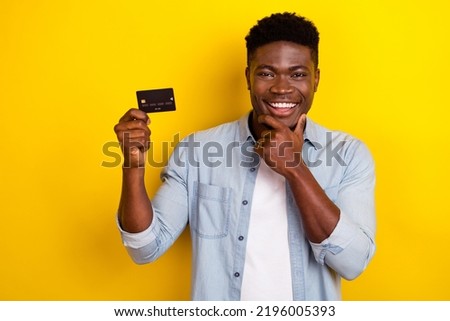 Photo of minded guy hold credit card think about buying income cashback isolated shine color background