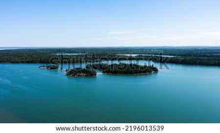 Aerial drone view of St. Mary's River between Lake Superior and Lake Huron with water channels passing through landscapes between Canada and The Unites States of America. Islands between countries. Royalty-Free Stock Photo #2196013539