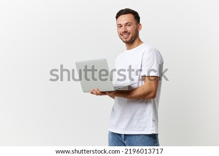 Happy tanned handsome man in basic t-shirt chatting with friends by laptop look at camera posing isolated on white studio background. Copy space Banner Mockup. Gadgets lifestyle Social media concept