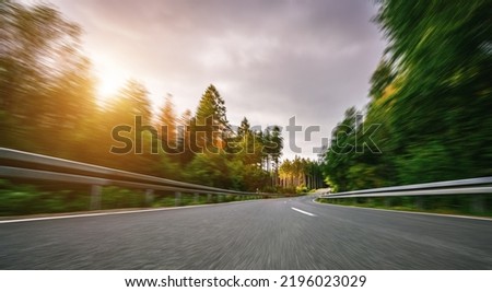 highway into Silent Forest in spring with beautiful bright sun rays - wanderlust