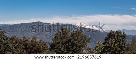 Panoramic landscape view. Hills and mountains covered with green pine forest, snow covered mountain peaks on mountain range in British Columbia Canada-Travel photo, nobody, copy space for text