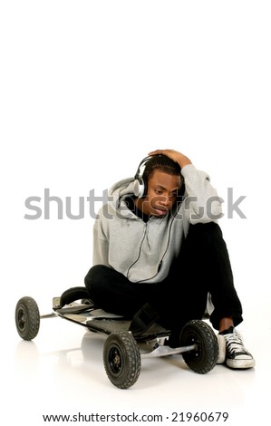 Handsome youngster, black African American teenager with mountain-board and headset, hip hop urban culture.  Studio white background