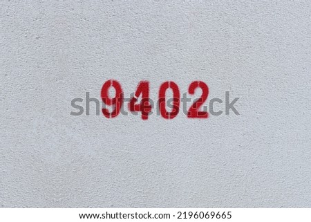 Red Number 9402 on the white wall. Spray paint.
