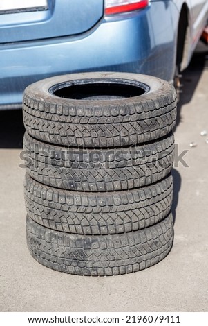 4 new tires that change tires in the auto repair service center, blurred background, the background is a new car in the stock blur for the industry, a four-wheeled tire set at a large warehouse