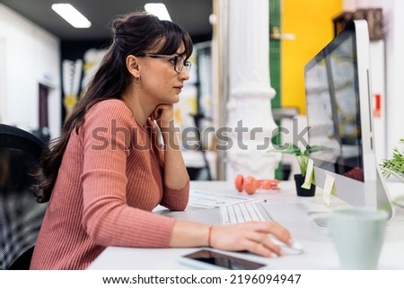 Focused office worker using computer and working in the office. Co-working concept.