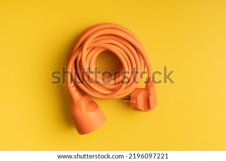 Orange extension Power Cord on the yellow background. Royalty-Free Stock Photo #2196097221