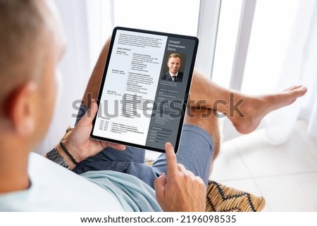 Man looking at his CV document on tablet computer to apply for a new job 