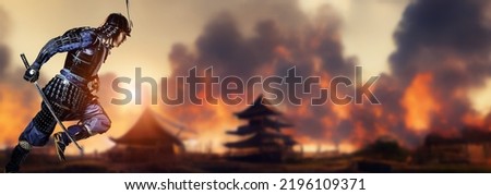 A samurai running through a burning battlefield. The concept of a period drama. Royalty-Free Stock Photo #2196109371