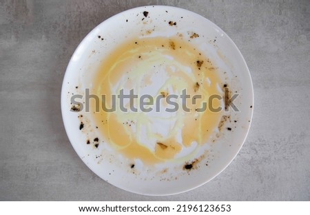 Fat on a dirty white plate after eating. Dish cleaner, anti-grease, dish care Royalty-Free Stock Photo #2196123653