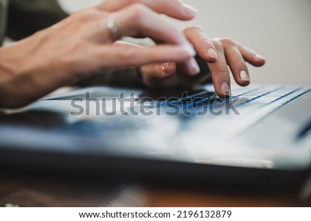 Female hand typing fast using laptop computer in a conceptual image of business work or education. 
