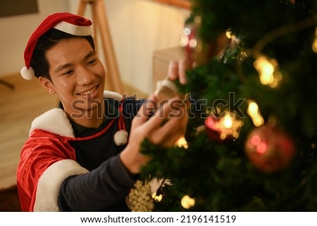 Happy man preparing for Christmas and New Year holidays season at home. Holidays preparation and creativity concept