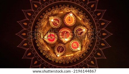 Deepavali Diwali, Hindu Festival of lights celebration. Diya oil lamp lit on traditional Puja thali, top view. Royalty-Free Stock Photo #2196144867