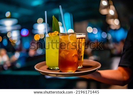 glasses alcohol cocktail set and beer on a waiter tray in bar