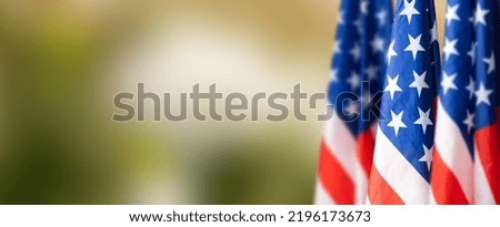 Group of American flags in green background.