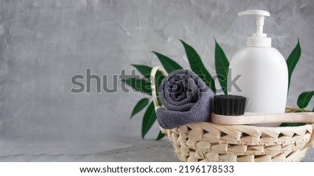 Gray towel, body massage brush, black bristle brush, foot penza, green ailanthus branch on gray background, bath accessories concept, bath products Royalty-Free Stock Photo #2196178533