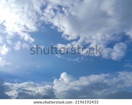 Beautiful white clouds on deep blue sky background. Elegant blue sky picture in daylight. Large bright soft fluffy clouds are cover the entire blue sky. Cumulus clouds against blue sky. No focus