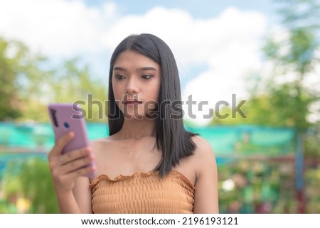 A serious woman looks unenthusiastic while looking at her phone. Disappointed at her likes and comments. Feeling unloved.