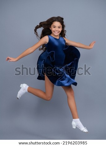 Full length teenager with movement dress. Young teen child with flowing skirt. Teen girl fluttering dress in motion, isolated on gray. Royalty-Free Stock Photo #2196203985
