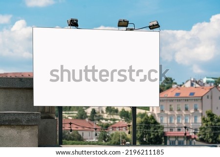 Empty white banner fixed on urban bridge against cityscape and blue sky