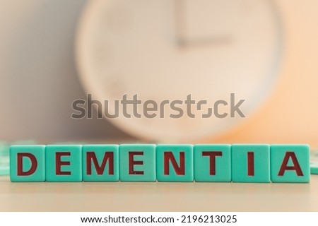 The word DEMENTIA made of small colorful cubes and many scrambled letters on the table. The loss of cognitive functioning thinking, remembering, and reasoning . High quality photo