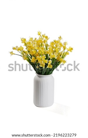 Close-up shot of a bouquet of realistic artificial orchids in a white vase. The vase of yellow flowers is isolated on a white background. Front view. Royalty-Free Stock Photo #2196223279