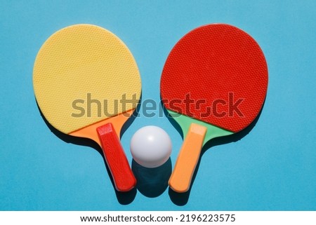 table tennis rackets and table tennis ball on a blue background, no person Royalty-Free Stock Photo #2196223575