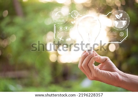 Hand holding light bulb with icons energy sources for renewable, sustainable development. Ecological friendly and sustainable environment concept