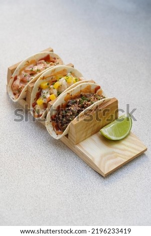 Tacos set with meat and vegetables in tortilla, close-up. Three Mexican tacos