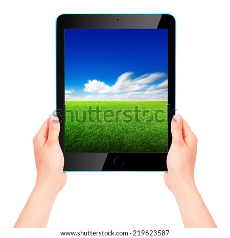 Tablet computer with blue sky and green grass on the screen