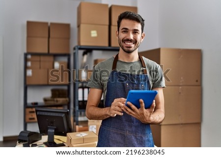 Young hispanic man business worker using touchpad at storehouse Royalty-Free Stock Photo #2196238045