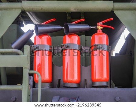 Three fire extinguishers. Fire extinguishers with nozzles are fixed on car. Flame extinguishing equipment. Fire extinguishers for special equipment. Security. Red ballons with sprayers