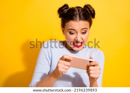 Photo of pretty funny girl dressed white shirt looking game modern device isolated yellow color background Royalty-Free Stock Photo #2196239893