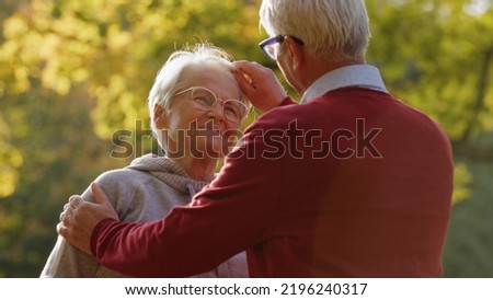 Joy of retirement. Older senior caucasian heterosexual couple. Man gently touches his beloved wife's gray hair and looks her in the eye. High quality photo Royalty-Free Stock Photo #2196240317