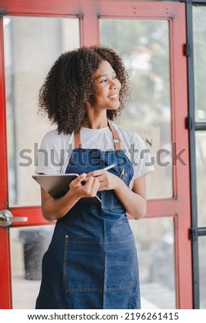 African American Female Small Business Owners
holding a laptop standing at the entrance to the store Coffee leaning on door with open sign SME entrepreneurs business