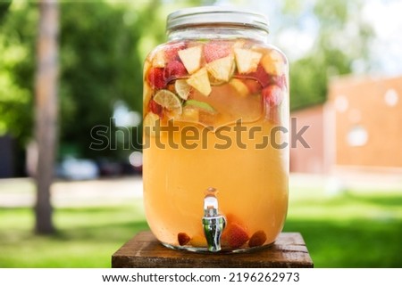 Refreshing lemonade with lime, strawberry and pineapple in glass jars with tap. Concept of drinks, summer, bar, rest, healthy food. Horizontal photo