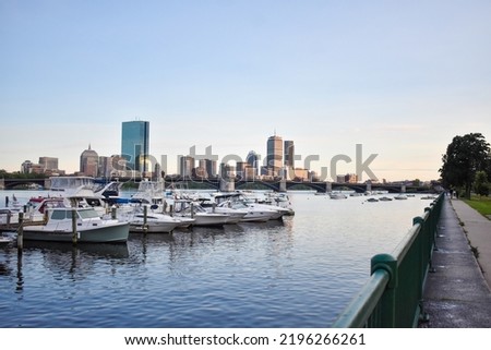 Boston cityscape with boats and a railing in the foreground