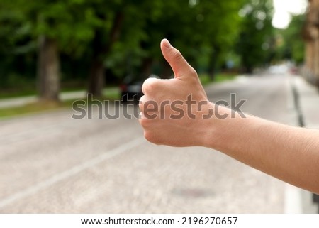 Man catching car on road, closeup and space for text. Hitchhiking trip