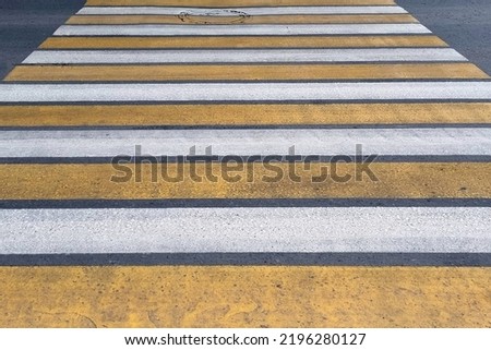 Yellow white crosswalk. Yellow-white crossing on the road. Zebra for pedestrians.