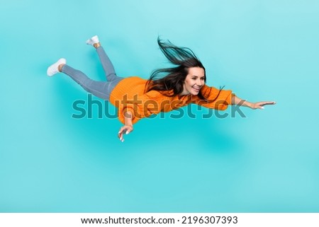Full length photo of pretty satisfied person fly falling toothy smile isolated on teal color background Royalty-Free Stock Photo #2196307393