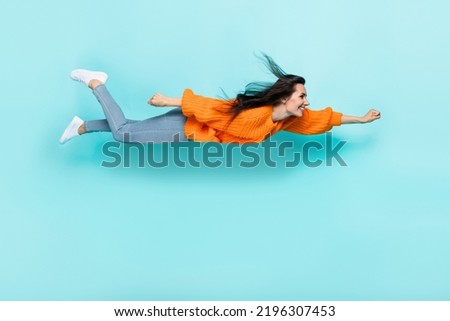 Full size profile photo of flying girl raise fist toothy smile good mood isolated on turquoise color background