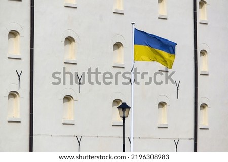 Ukrainian flag waving in wind on Polish building showing the support to the country